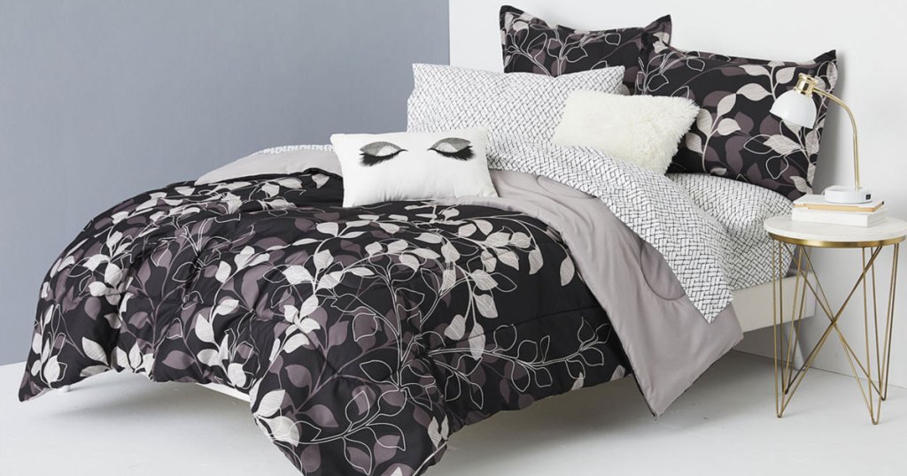 black and grey floral print comforter set on a bed