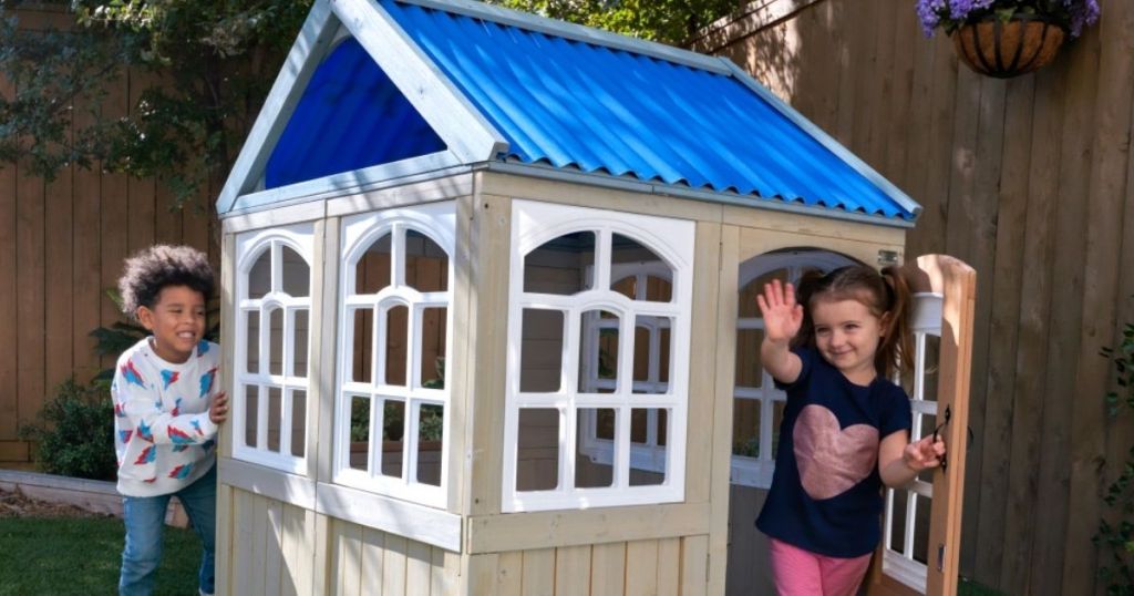 2 kids playing in KidKraft Cooper Playhouse outside