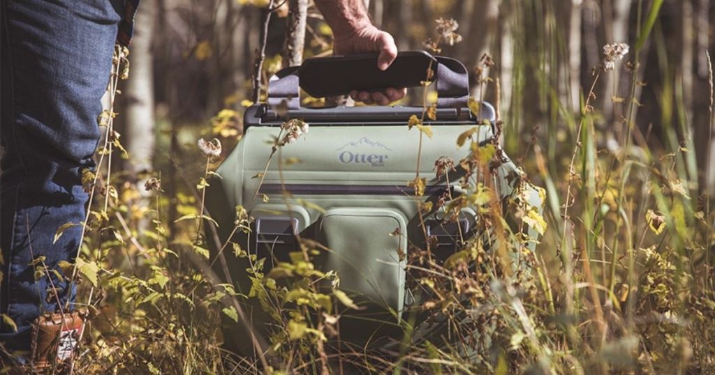 man carrying green OtterBox cooler