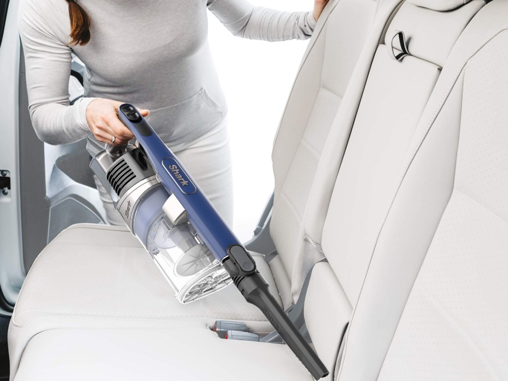 woman holding a shark pet cordless handheld vacuum