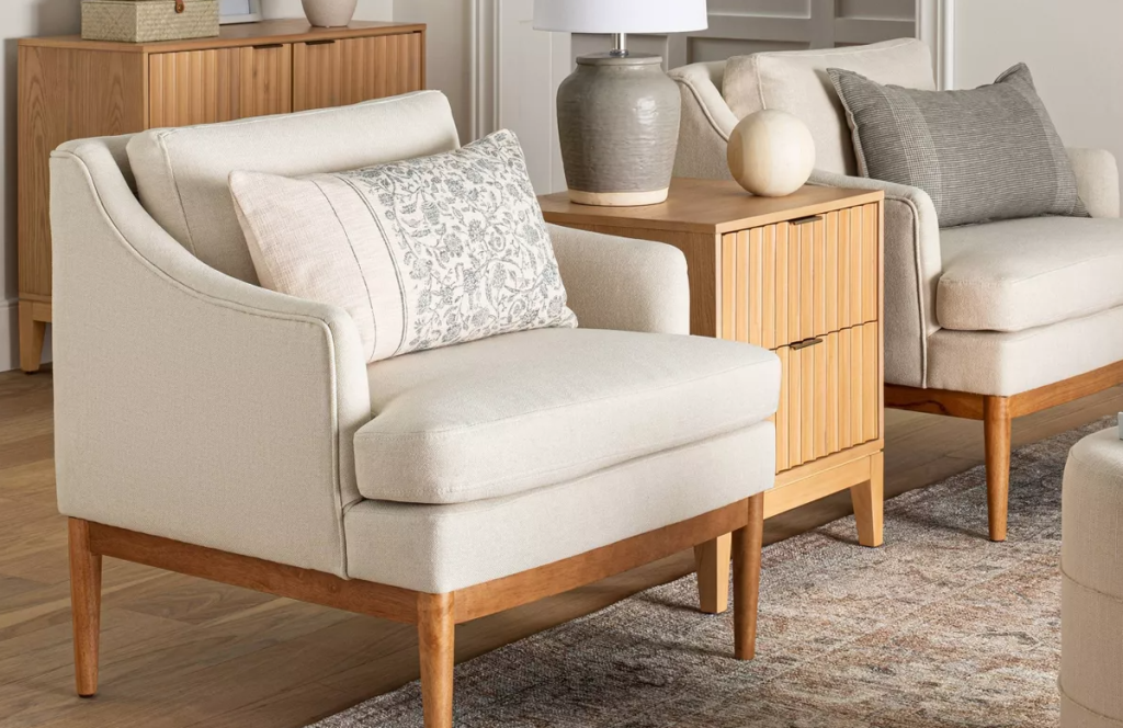 two cream chairs with a table between them