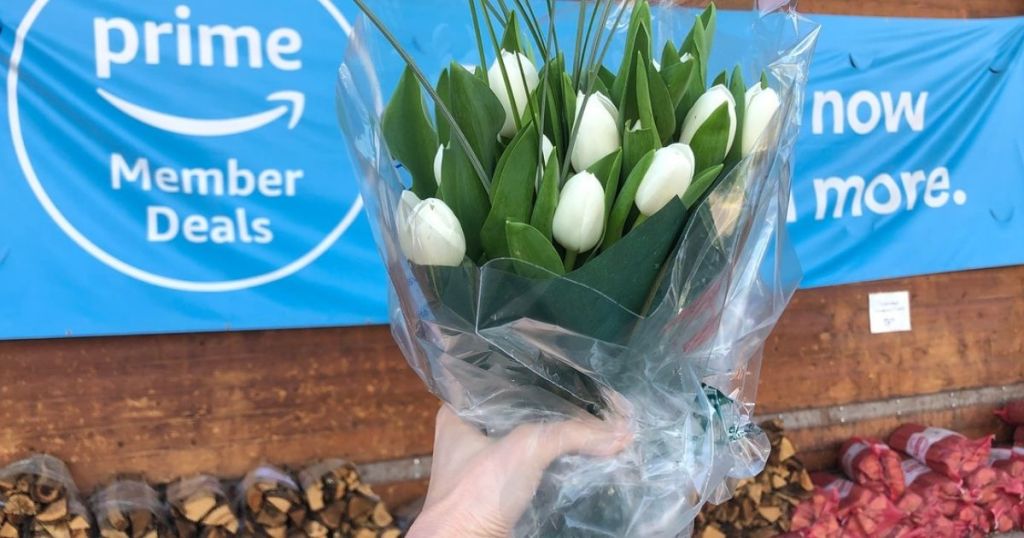 Whole Foods Tulips hed up in front of Amazon prime sign