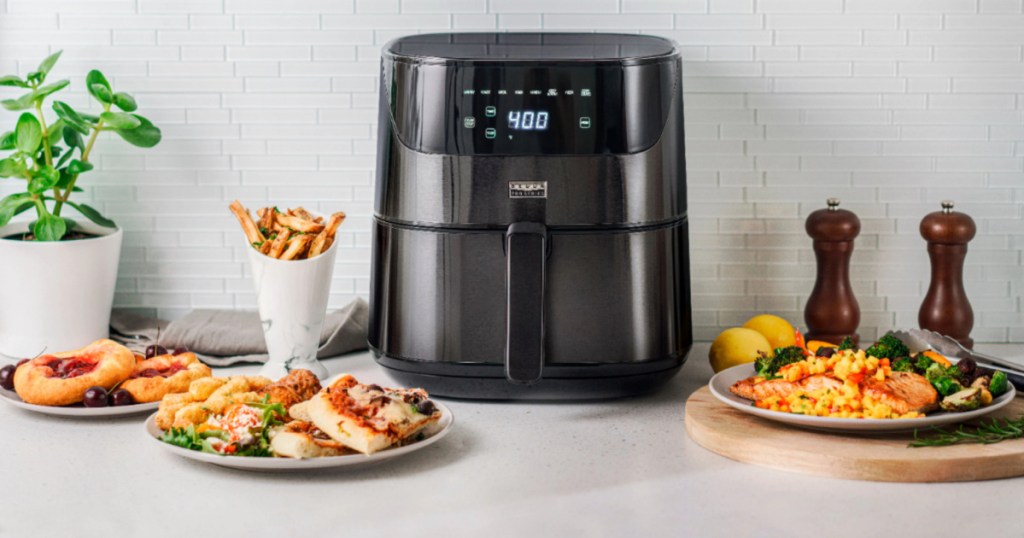 black air fryer surrounded by food on a counter