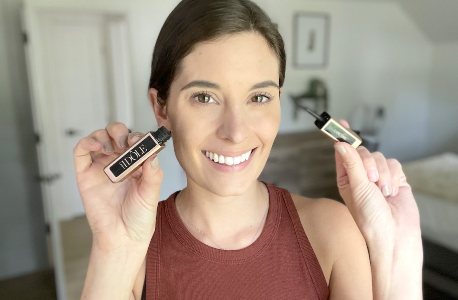 woman holding up lancome mascara smiling