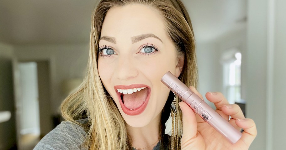 woman holding up maybelline sky high mascara