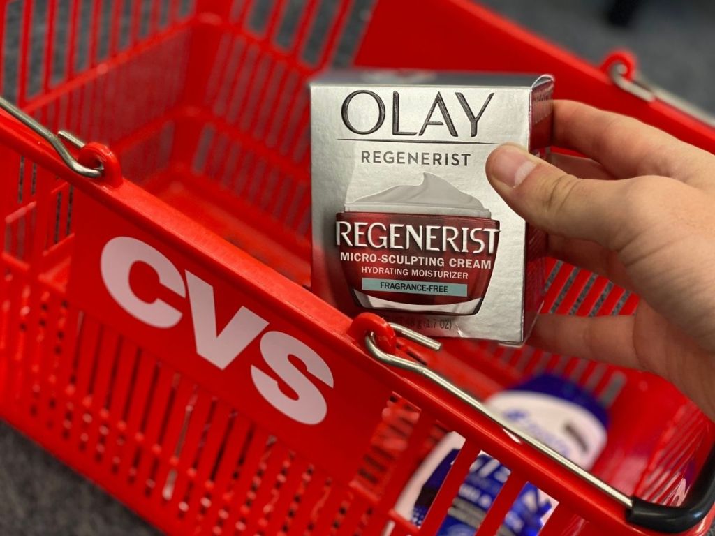 hand holding a box of Olay Regenerist by a CVS basket