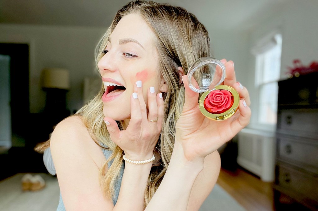 woman putting on rose cheeky blush 