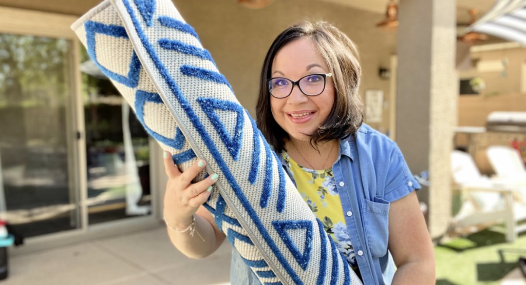 woman holding outdoor rug from boutique rugs