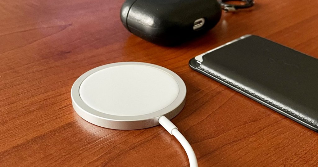 white apple wireless charger on a wood table