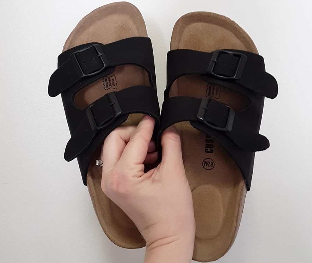 hand holding a pair of sandals