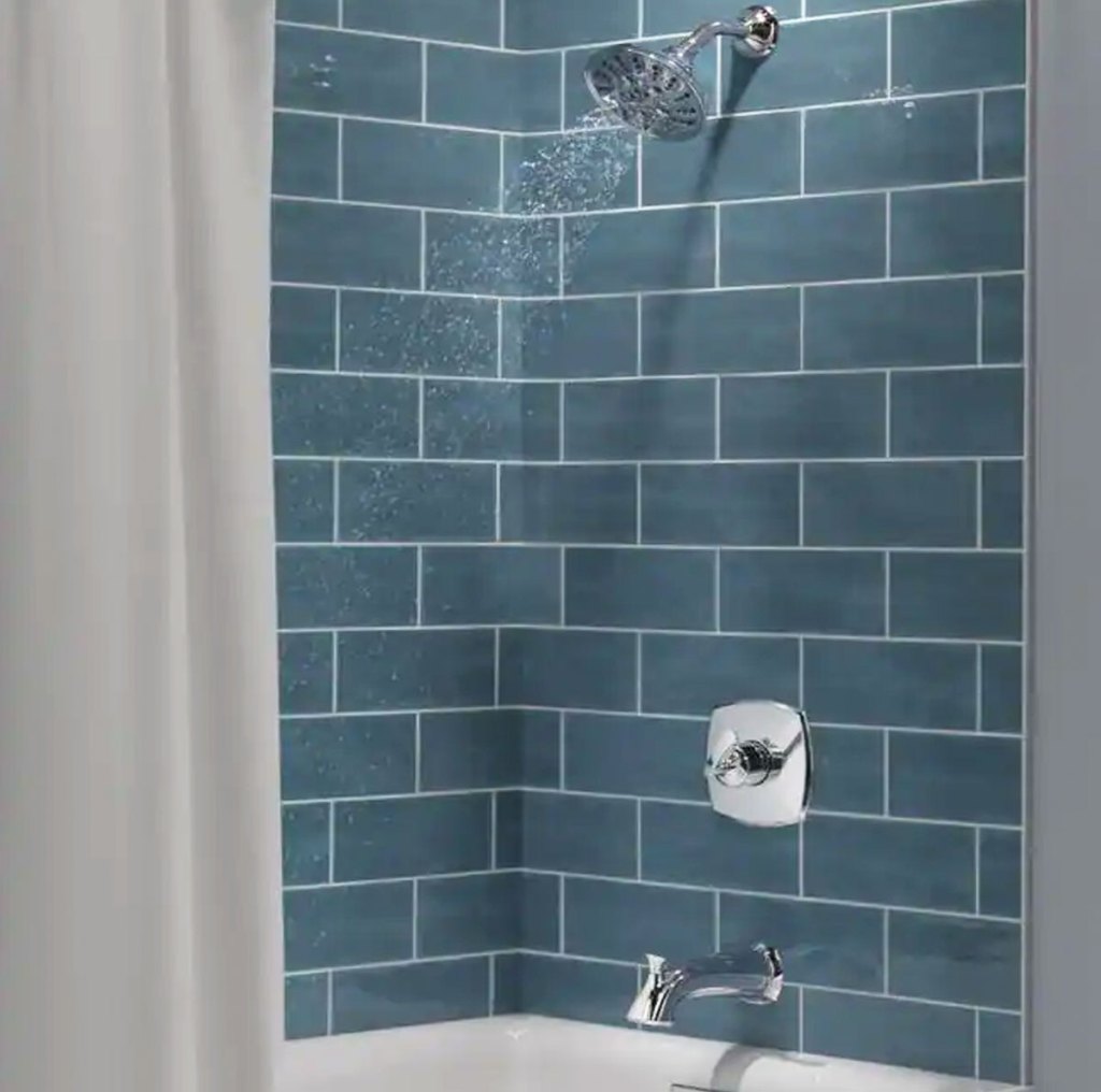 chrome shower and tub faucet on blue tiles