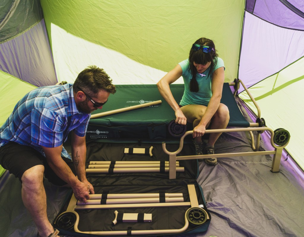 man and woman building a bunk bed cot