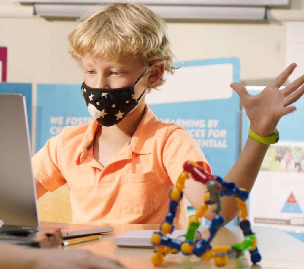 boy wearing face mask in front of laptop