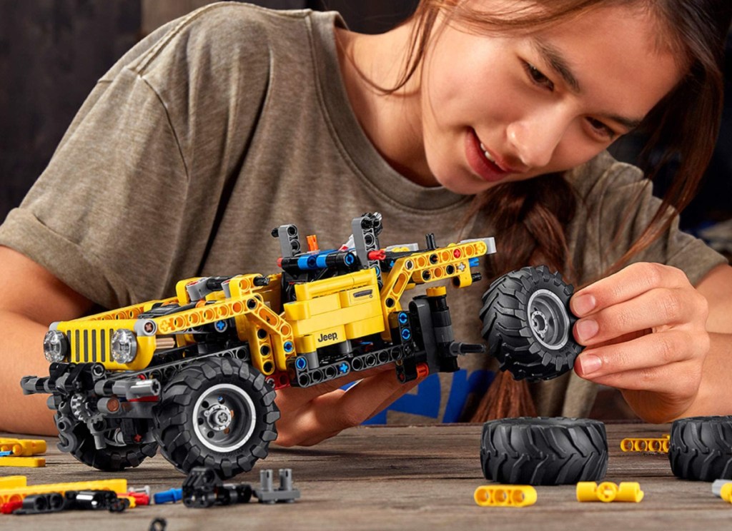 boy holding lego technic jeep wrangler