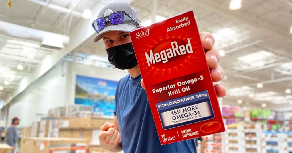 man holding up and pointing at a box of megared kill oil