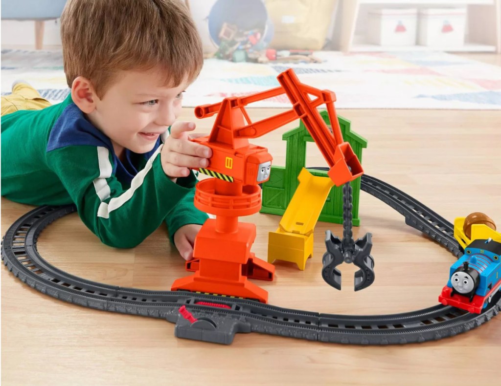 Boy playing with train set