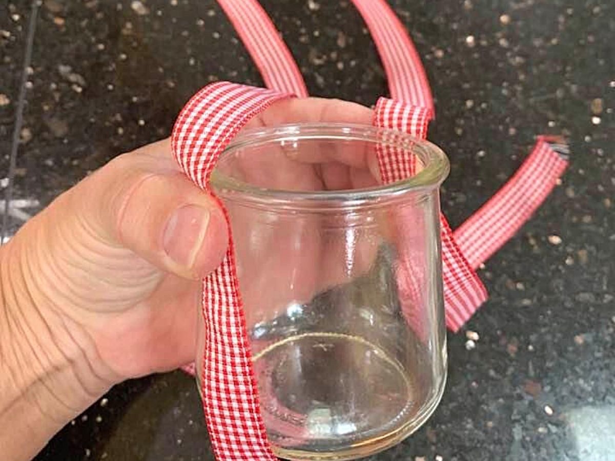 hand holding glass jar with ribbon