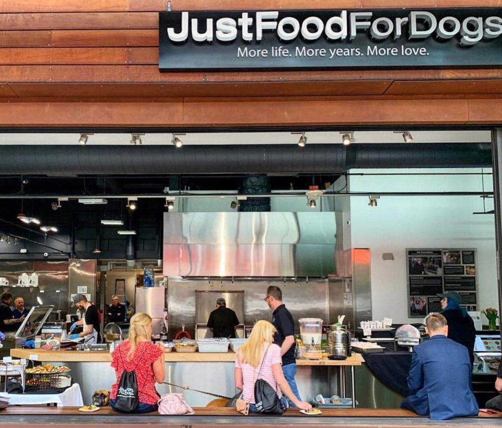 justfoodfordogs store front with people inside cooking
