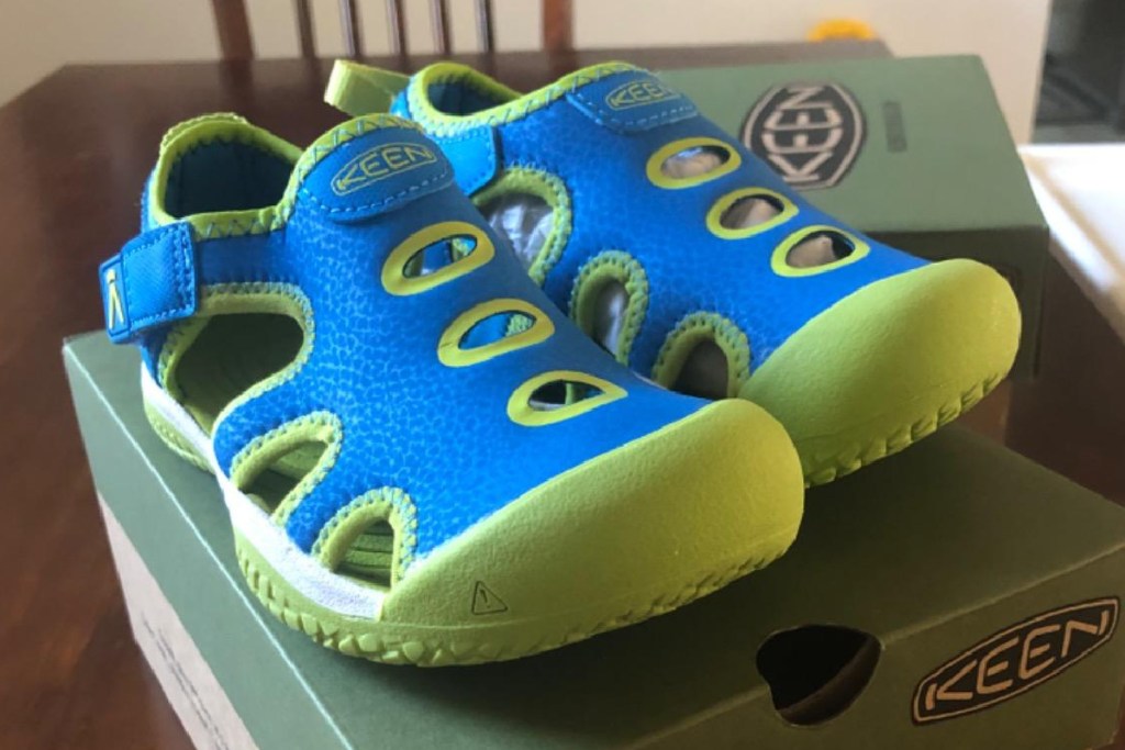 green and blue keen sandals on top of shoe box