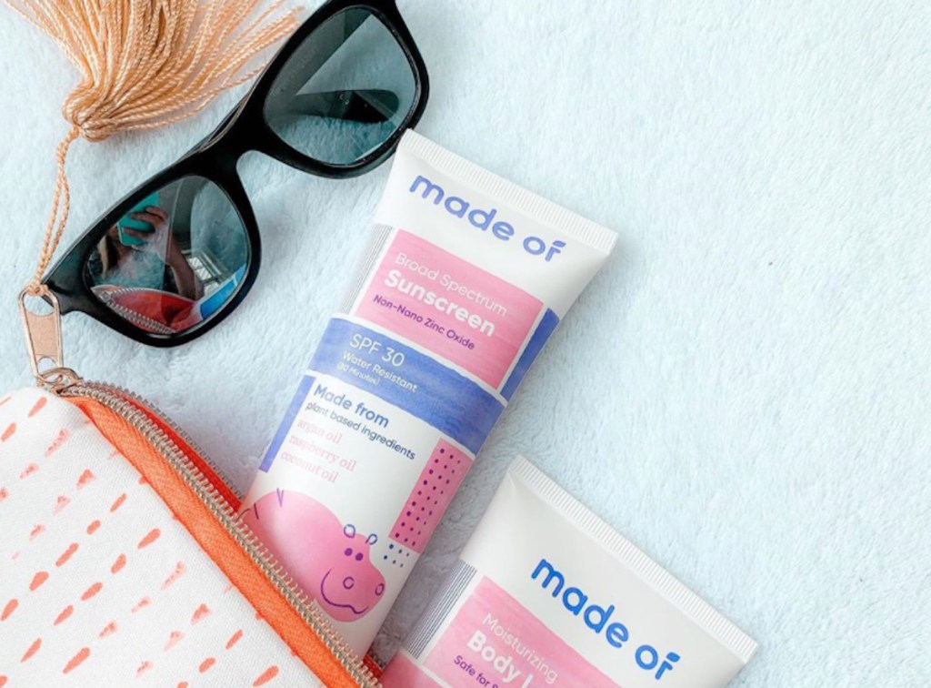 tube bottles of made of sunscreen lotion coming out of cosmetic bag with sunglasses