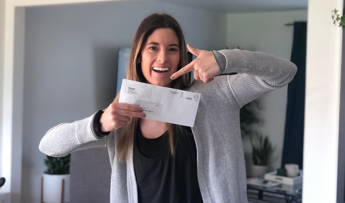 woman holding up envelope from Amazon rebate site