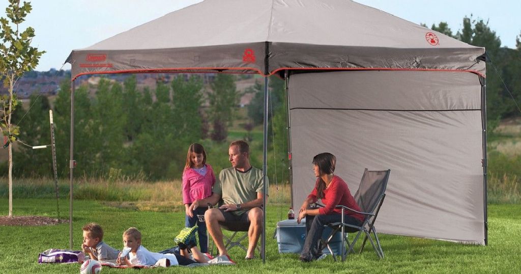 gray sun canopy with family under it 