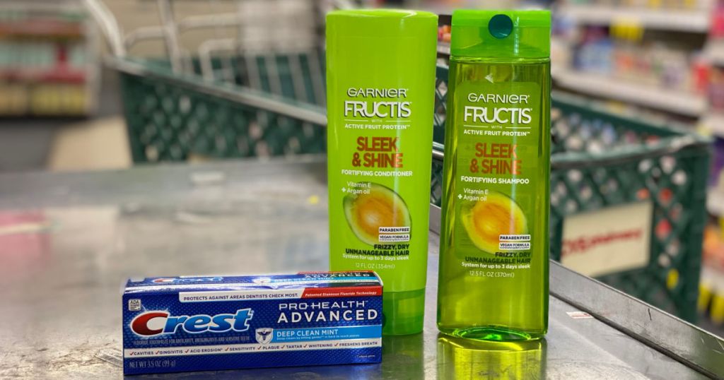 blue box of toothpaste and green shampoo on counter 