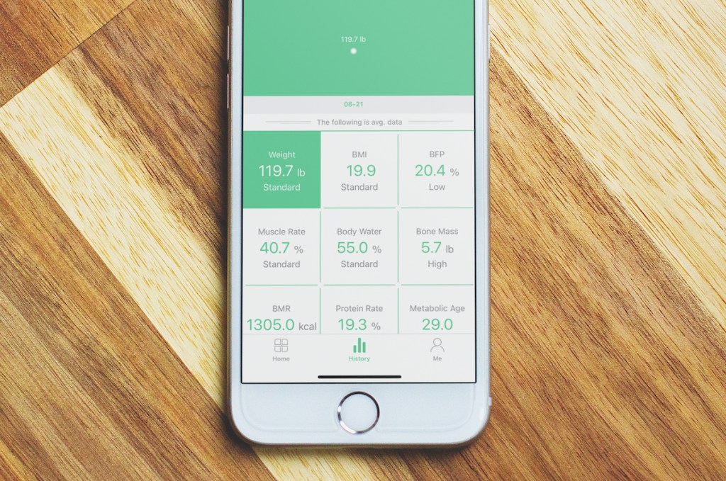 phone on wood surface with body stats on screen