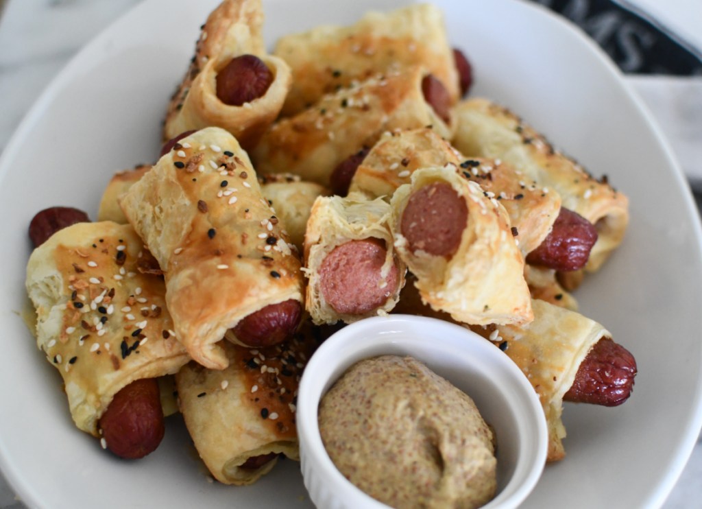 a platter of pigs in a blanket puff pastry snacks, an easy appetizer idea for kid parties