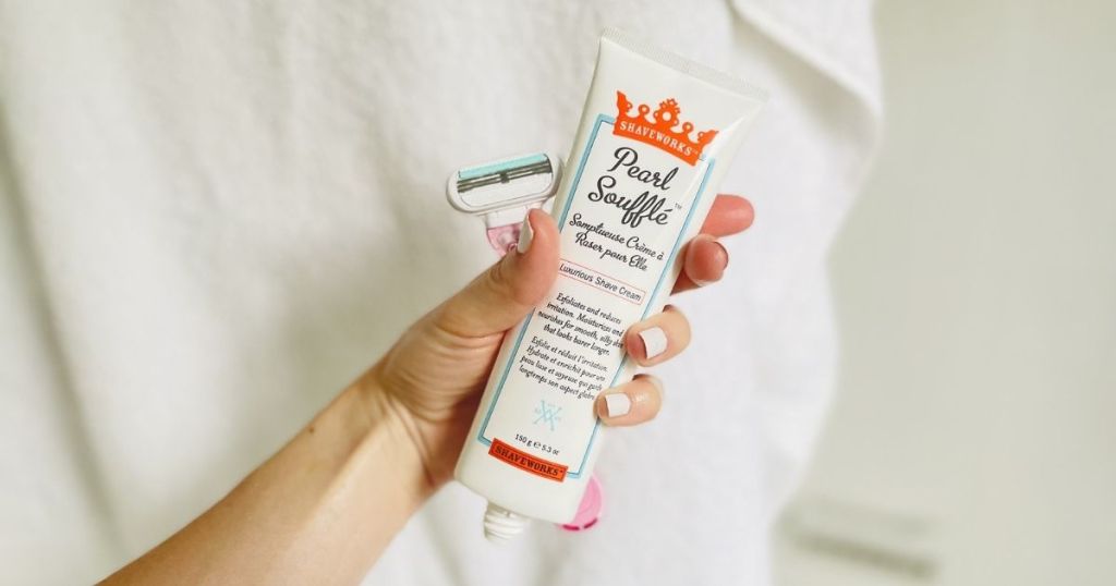 hand holding Shaveworks shaving cream and pink razor