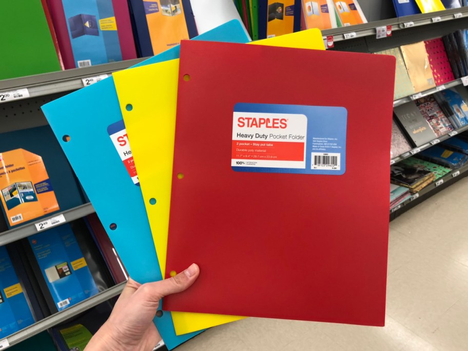 hand holding three folders