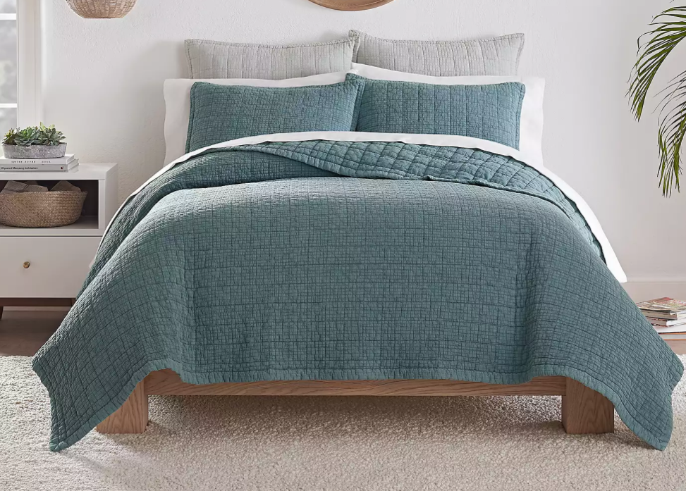 bed with a teal blanket and pillows