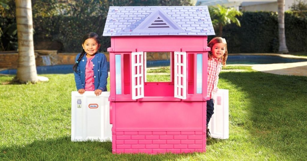 Little tikes playhouse with two little girls looking outside the window