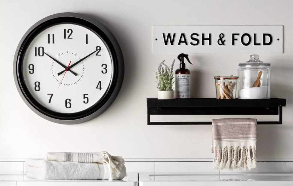 wall with a clock, sign and storage shelf