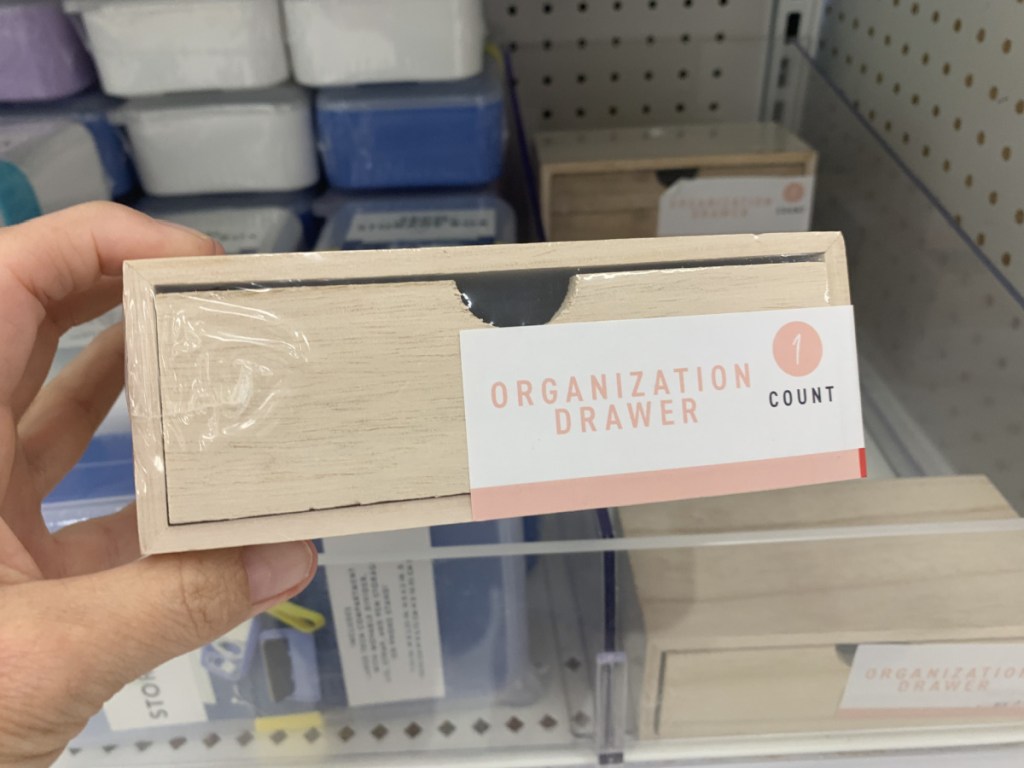 wooden desk drawer in hand near store shelving