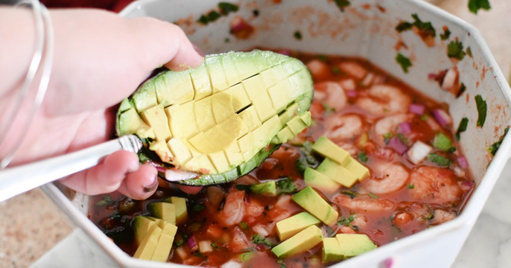 adding avocado to mexican shrimp cocktail