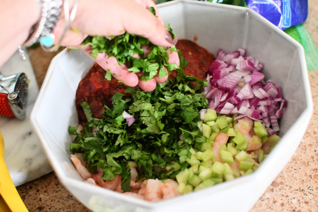 adding cilantro to mexican shrimp