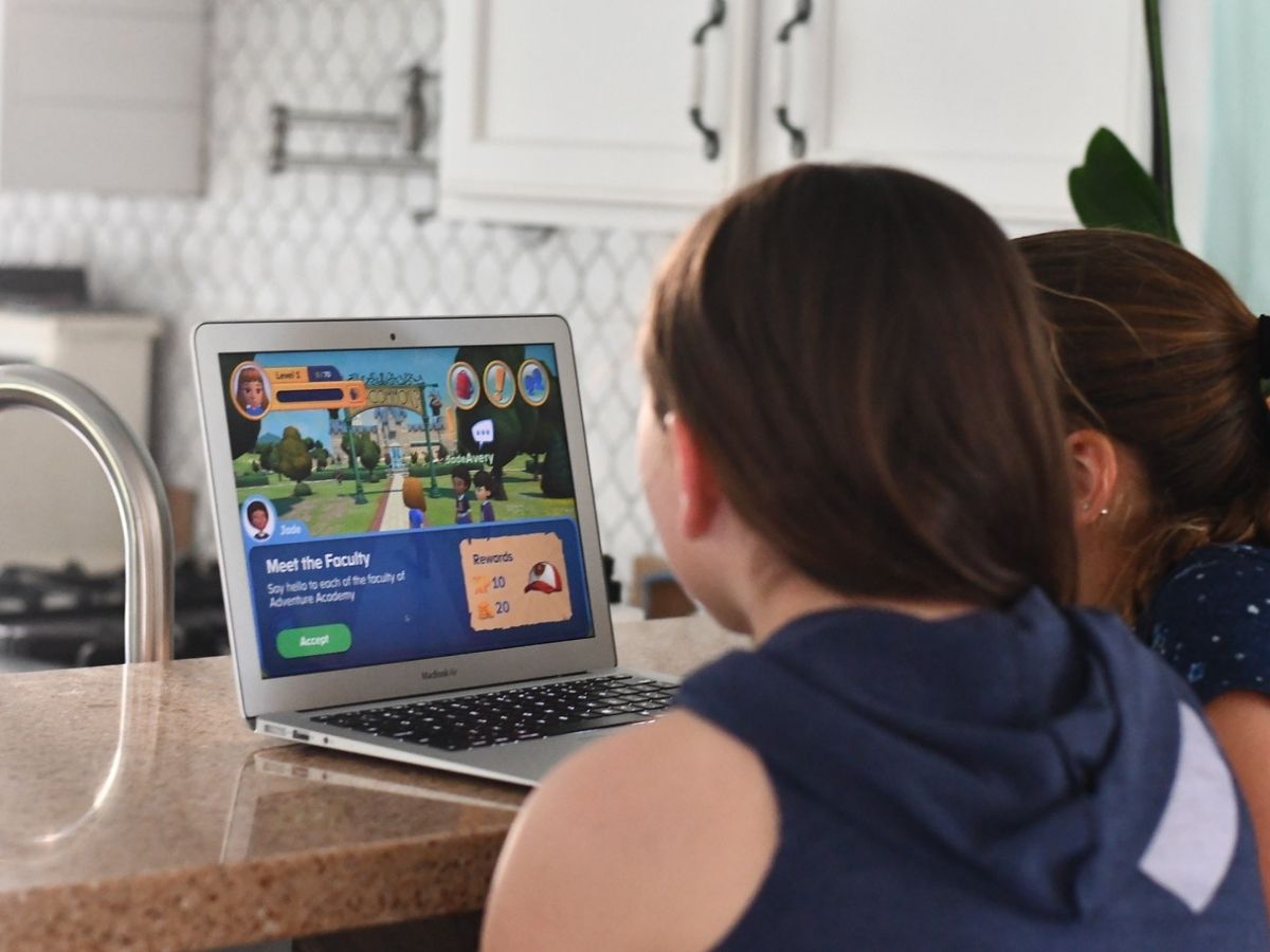 2 girls playing computer game on laptop