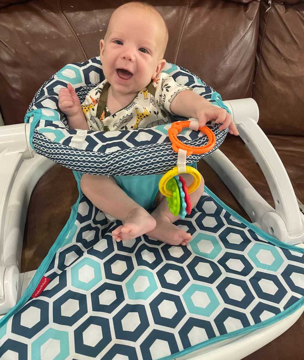 baby in seat on leather couch