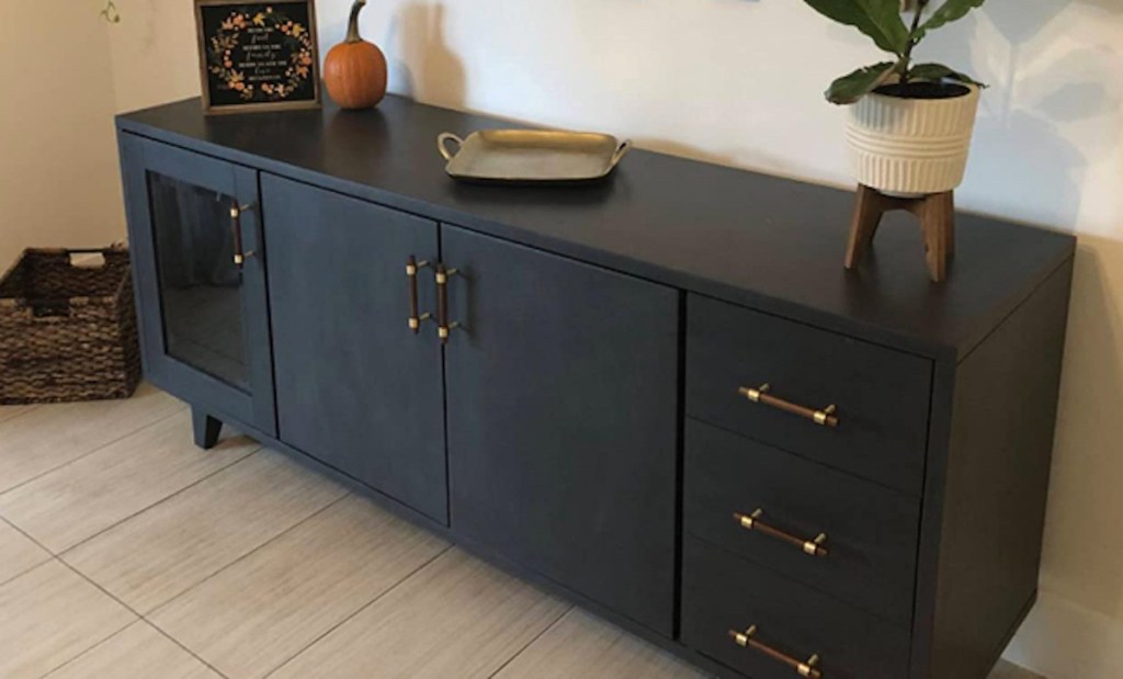 close up of black console side table with brown and gold knobs