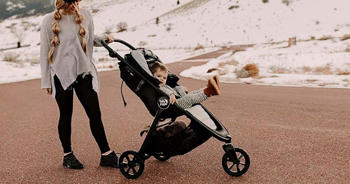 mom pushing stroller outside with baby