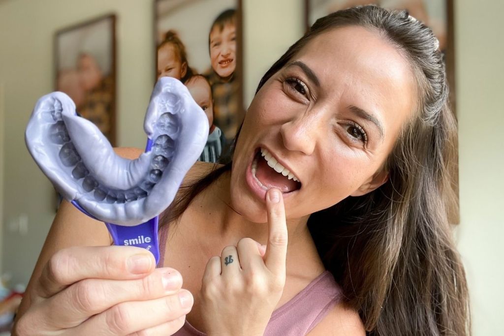 woman holding an impression kit from Smile Direct Club