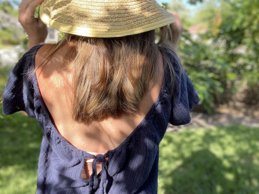 close up of women's swimsuit cover ups in navy on woman wearing beach hat