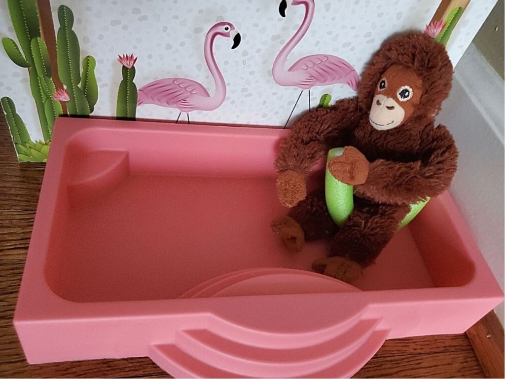 toy plush monkey sitting on pool noodle in toy pool
