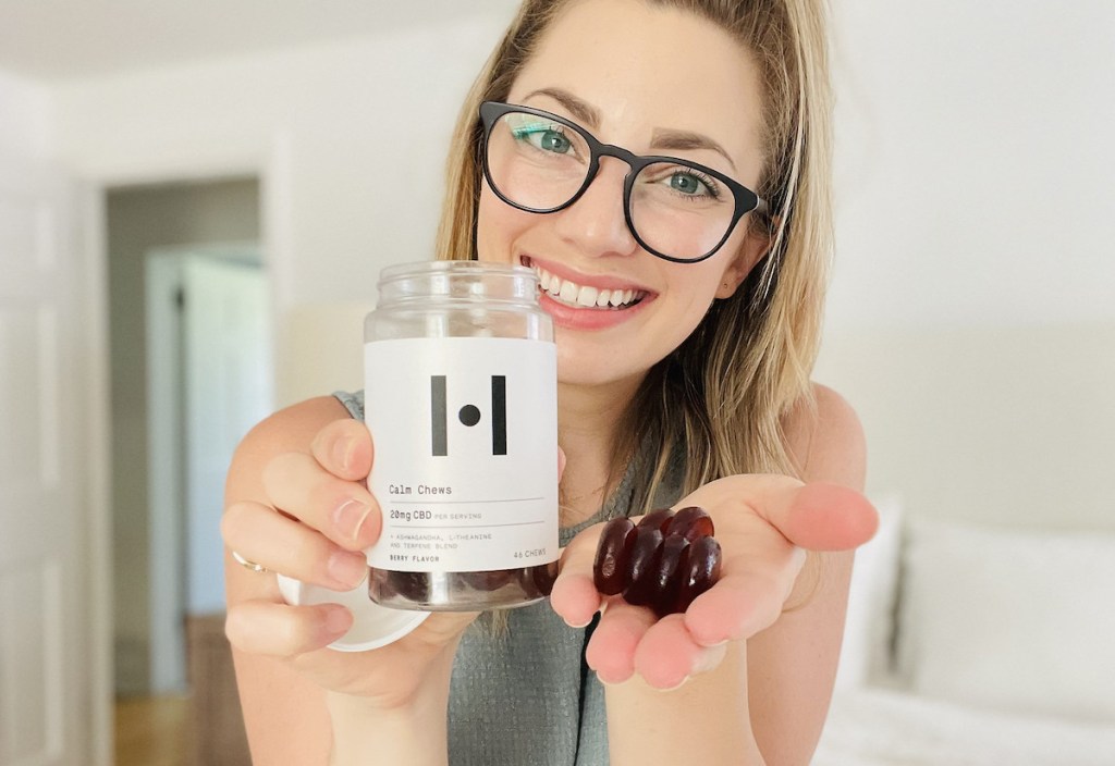 woman holding bottle of cbd gummies in hand