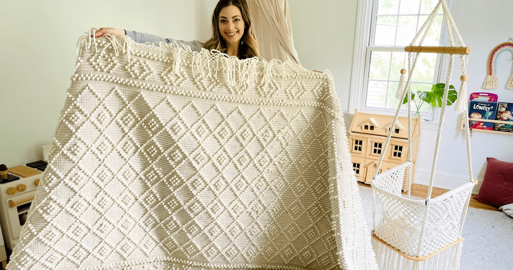 woman holding neutral boho rug 