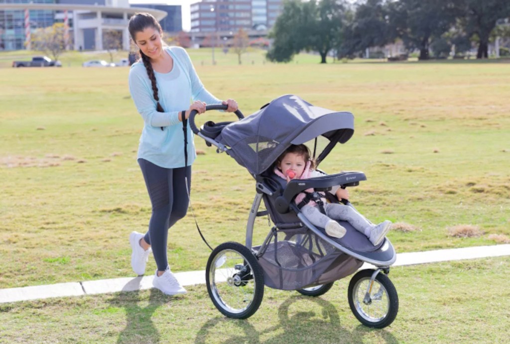 woman pushing jogging stroller outside