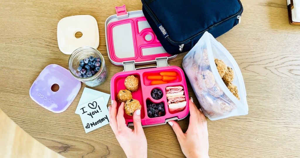 hand putting oatmeal ball into hot pink best lunch boxes for kids