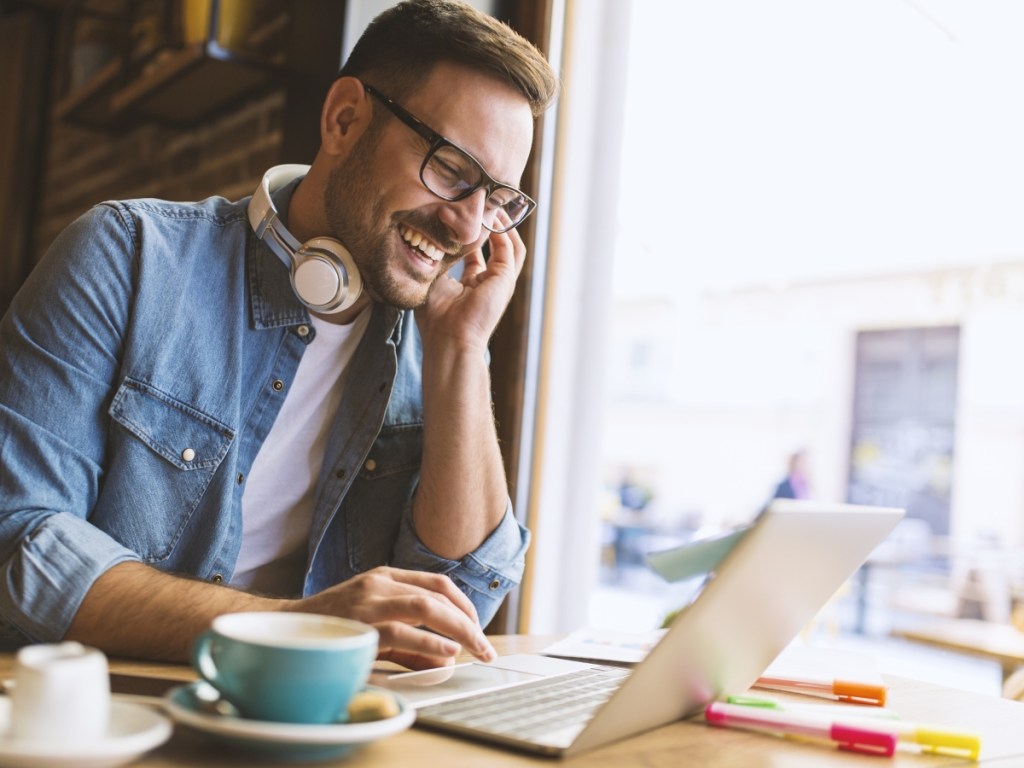 man wearing headphones and using laptop