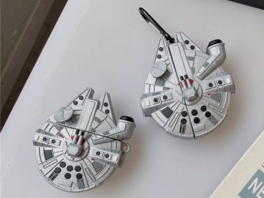 2 AirPods cases, both shaped like the Millenium Falcon